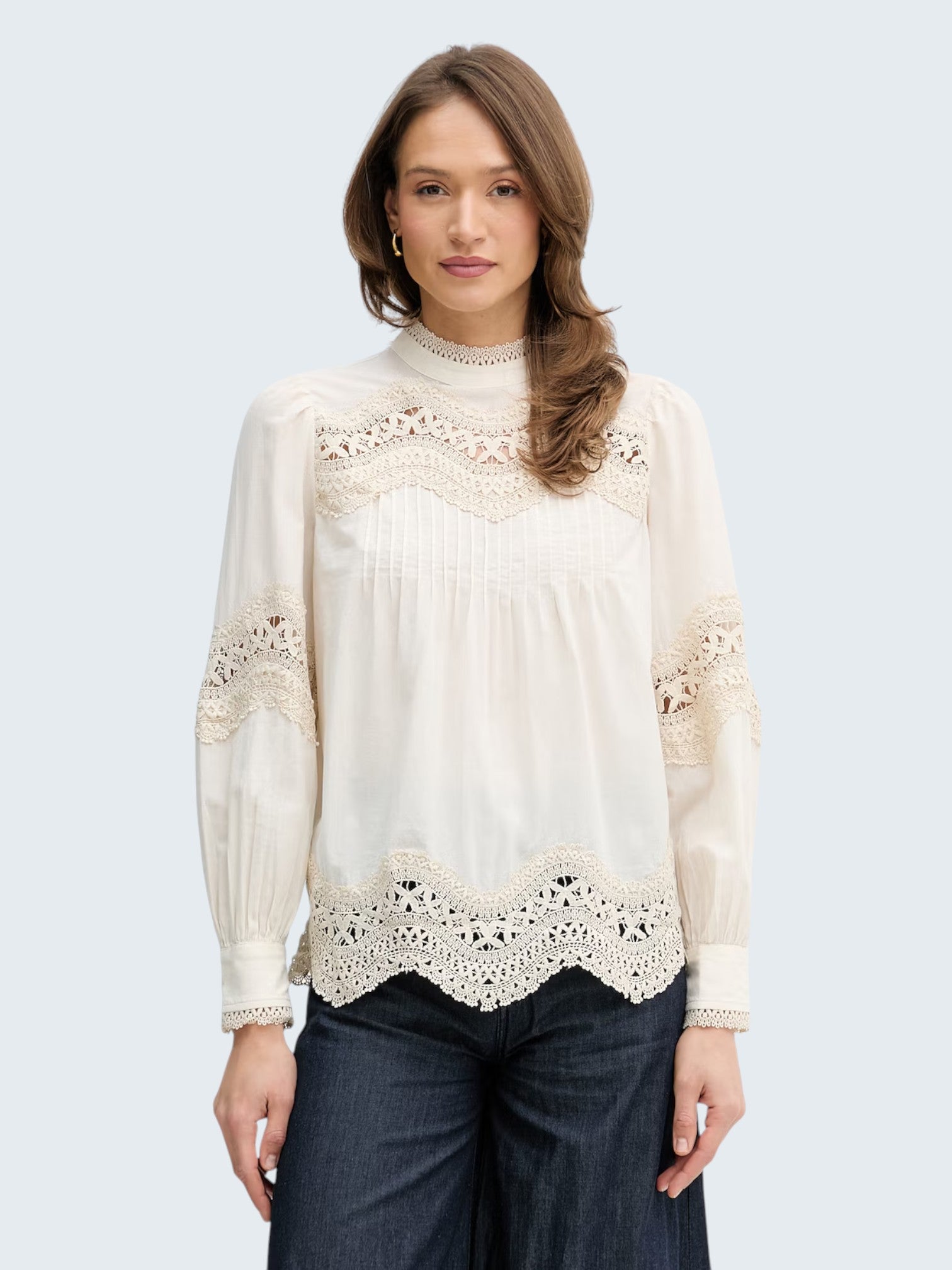 Oui-ua.store cream cotton blouse with lace trim, pintuck details, stand collar, and button back. Voluminous fit.