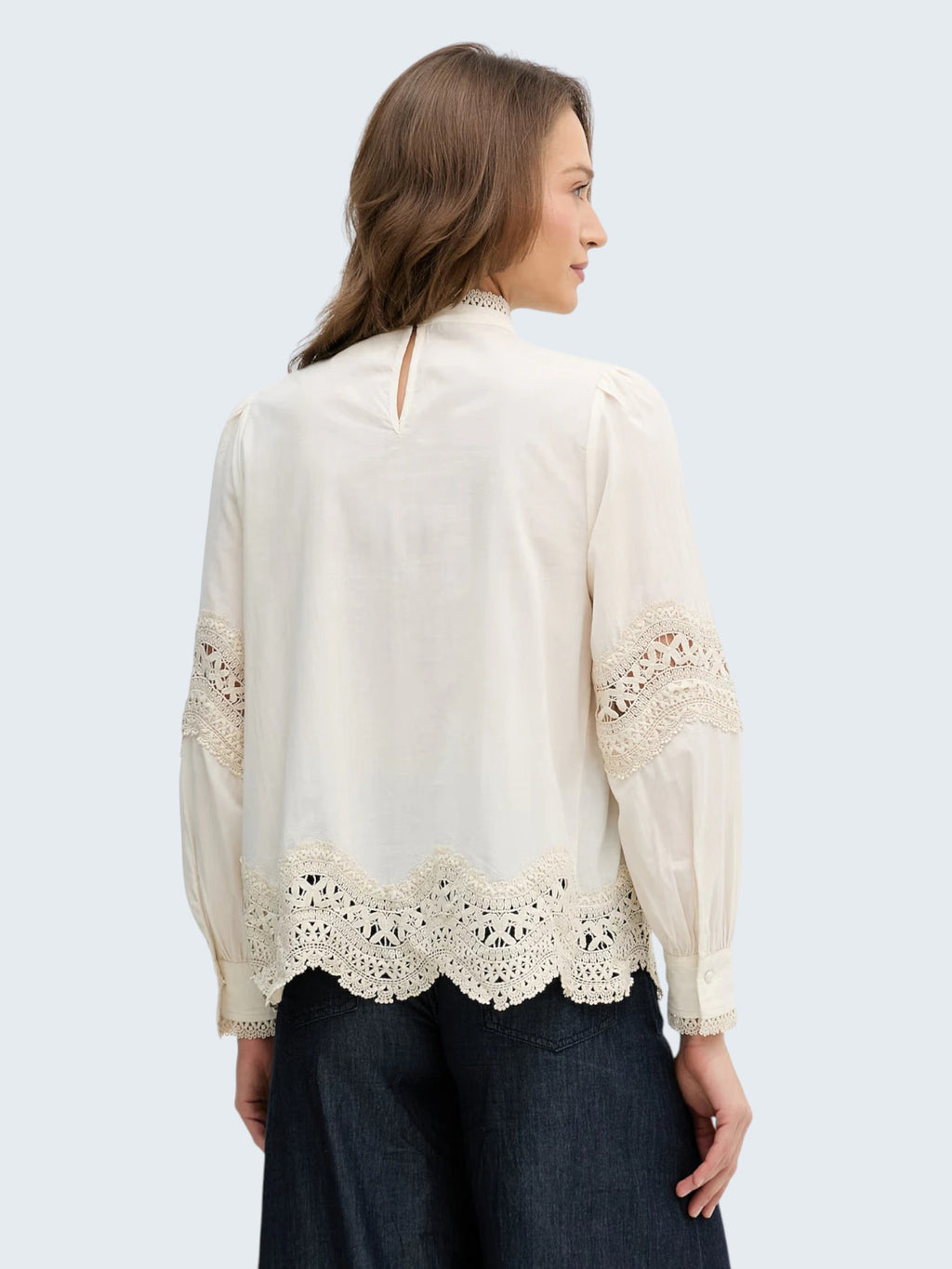 oui-ua.store cream cotton blouse with crochet lace trim on sleeves and hem, high neck with crochet detail, and button back closure.